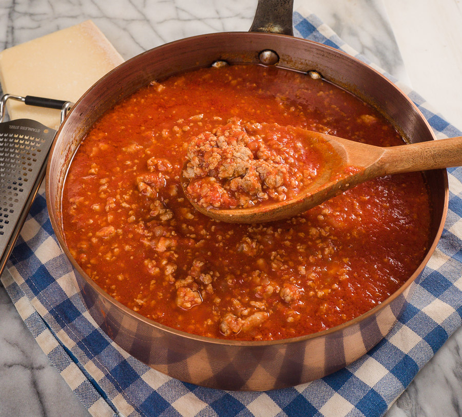 Neapolitan ragu in a pot with a ladle.