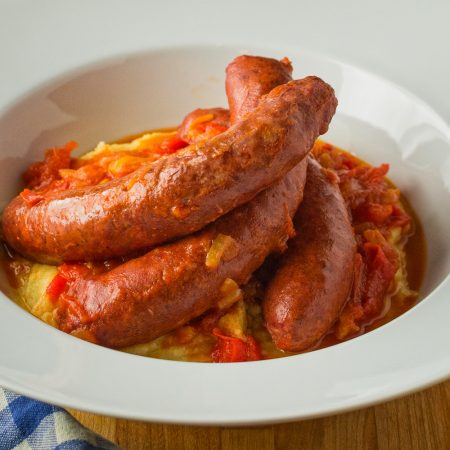 Upscale sausage with peppers served with parmesan polenta.