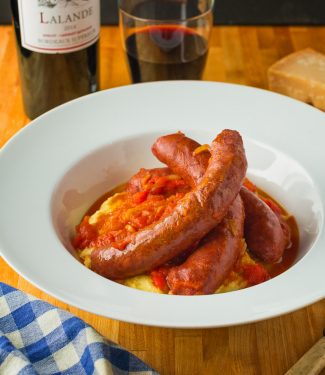 Upscale sausage with peppers served with parmesan polenta.