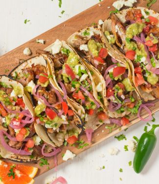Loaded carnitas tacos with queso, pico, pickled onions and avocado tomatillo salsa.
