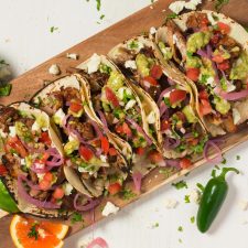 Loaded carnitas tacos with queso, pico, pickled onions and avocado tomatillo salsa.