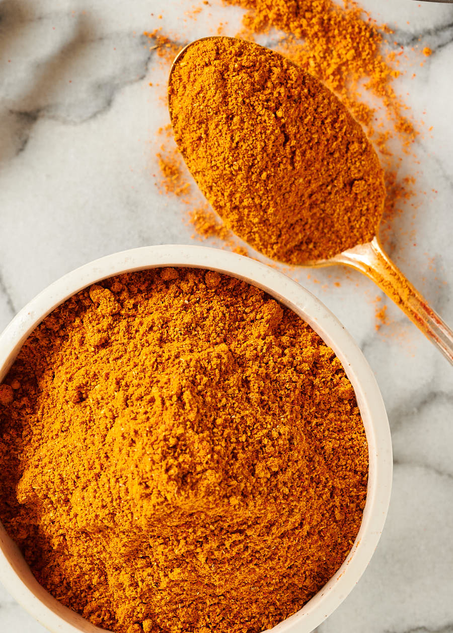 Indian restaurant spice mix in a bowl with a spoonful of spice from the top.