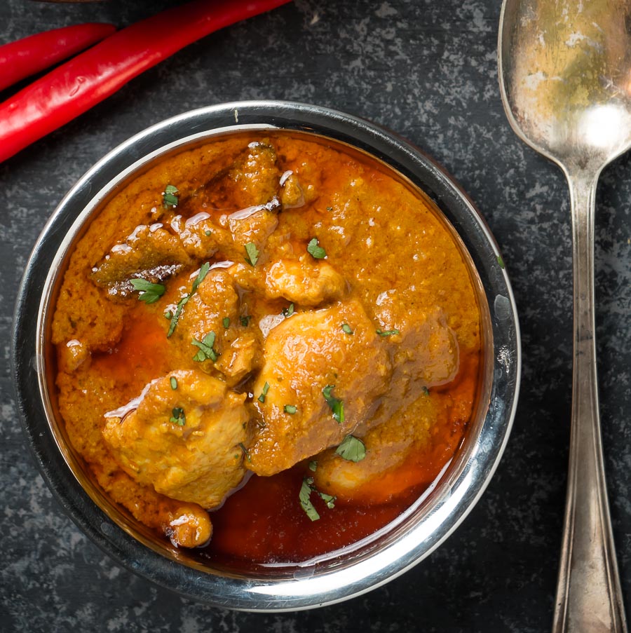 Chicken madras in an Indian copper bowl from above.