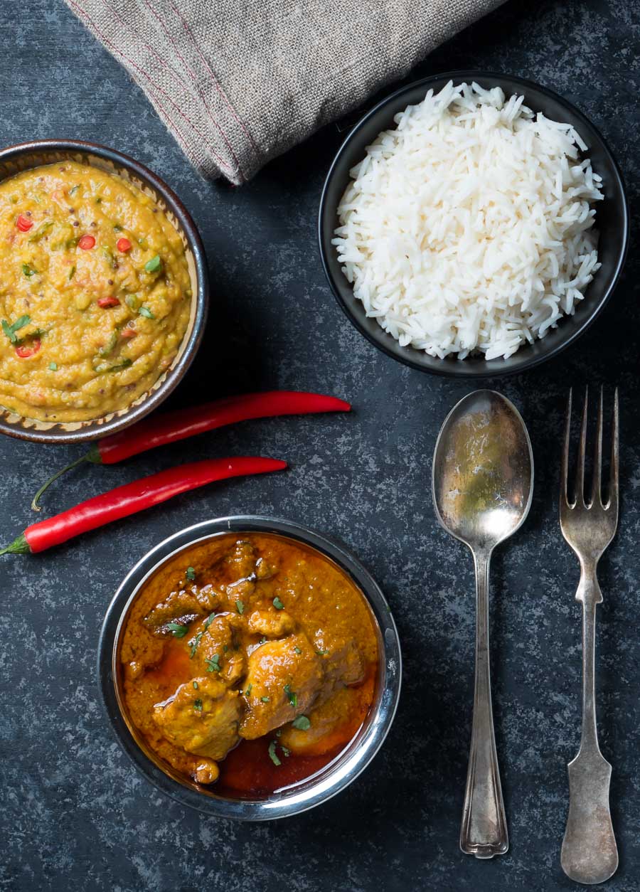 Chicken madras, masoor dal and rice serving bowls from above.