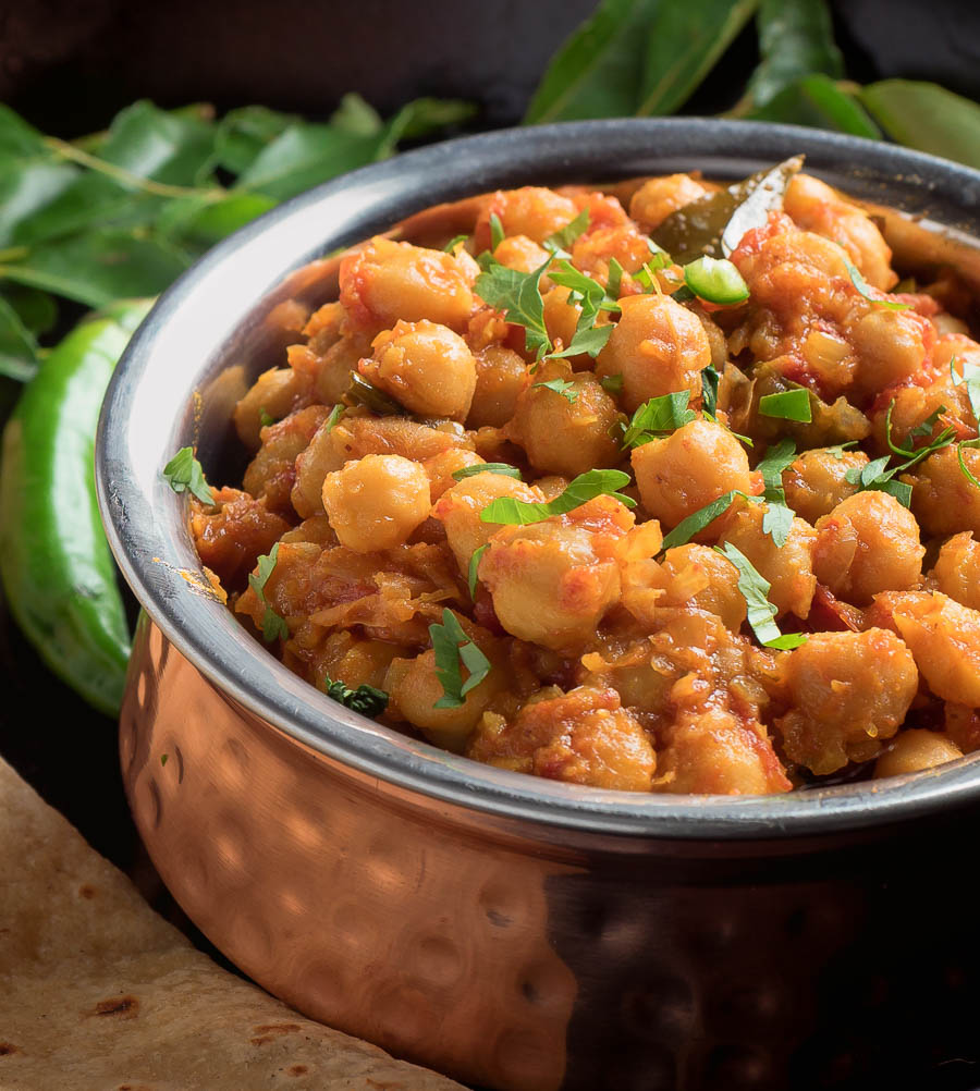 South Indian chana masala in a copper bowl close up.