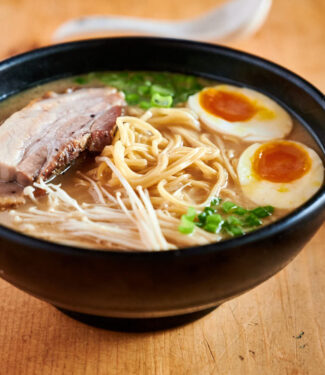 Tonkotsu ramen with egg, pork belly, enoki mushroom and green onion garnish