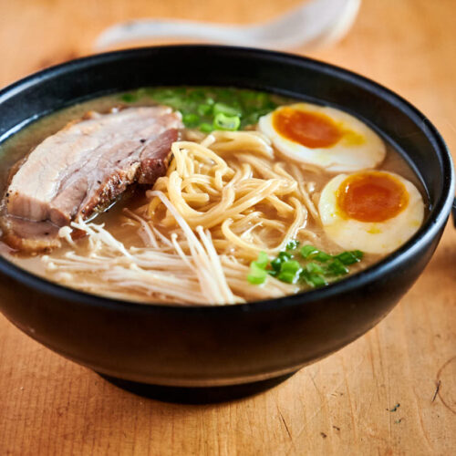 Tonkotsu ramen with egg, pork belly, enoki mushroom and green onion garnish