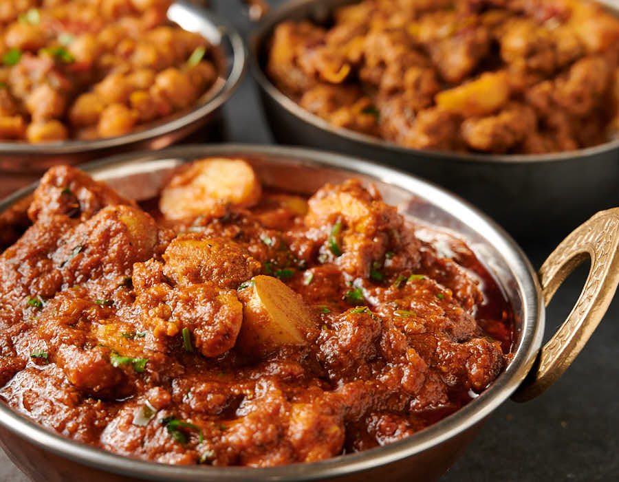 Close-up of aloo chicken curry in a bowl.