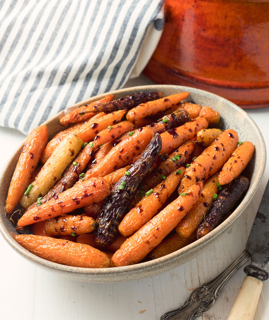 Balsamic roasted carrots in a clay bowl from above.