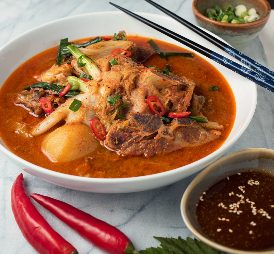Korean pork bone soup with red chilies in rich pork broth .