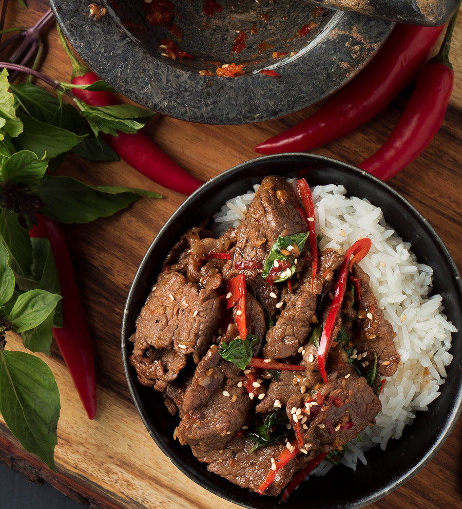 Thai basil beef in black bowl with jasmine rice from above.