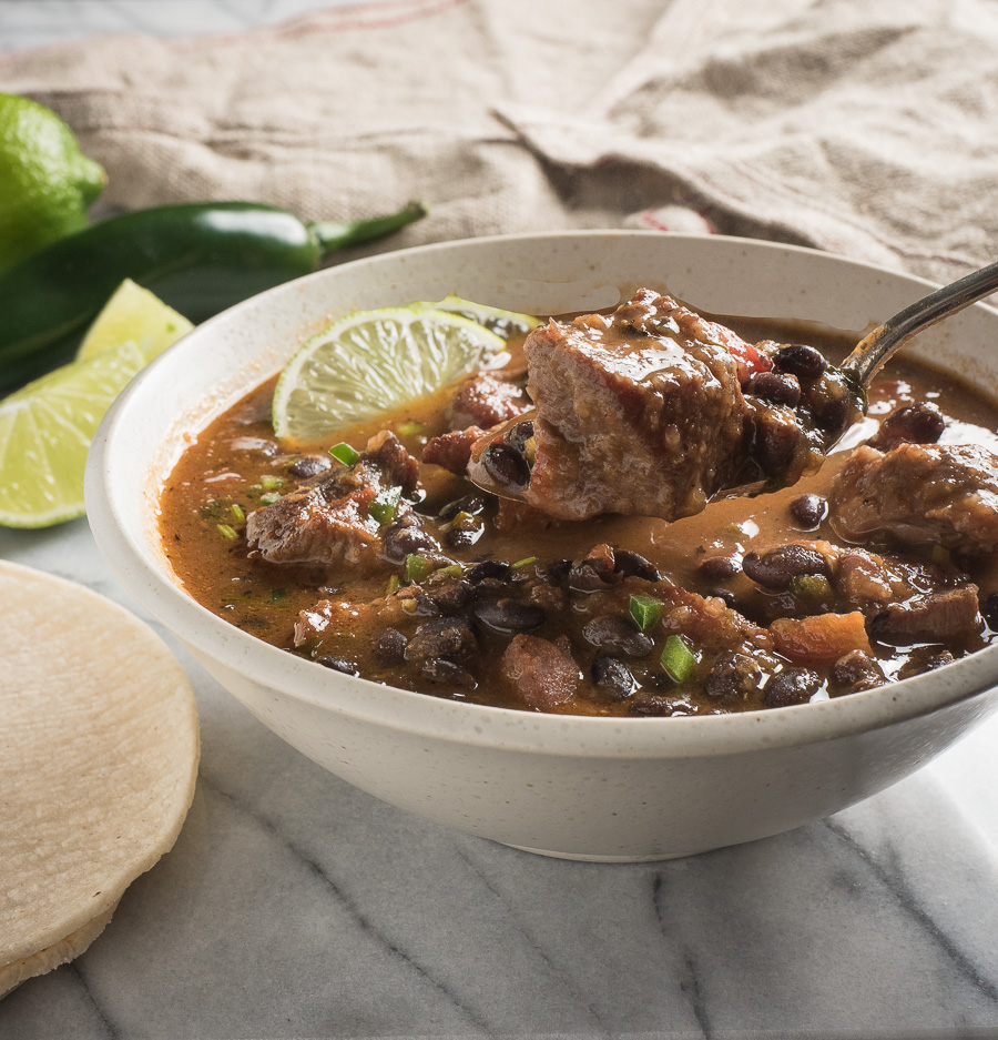 Taking a spoonful of Mexican pork and black bean stew.