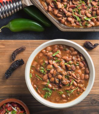 Mexican charro beans in a white bowl. View from above.