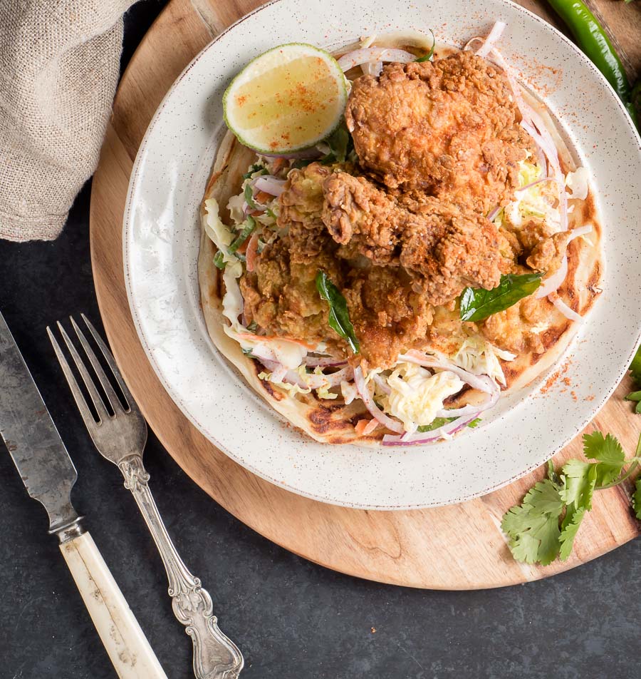 Kerala fried chicken on a bed of slaw from above.