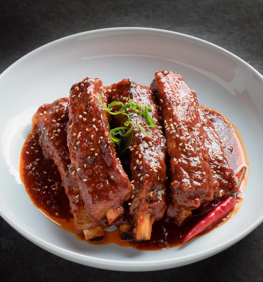 Korean braised pork ribs in a white bowl.