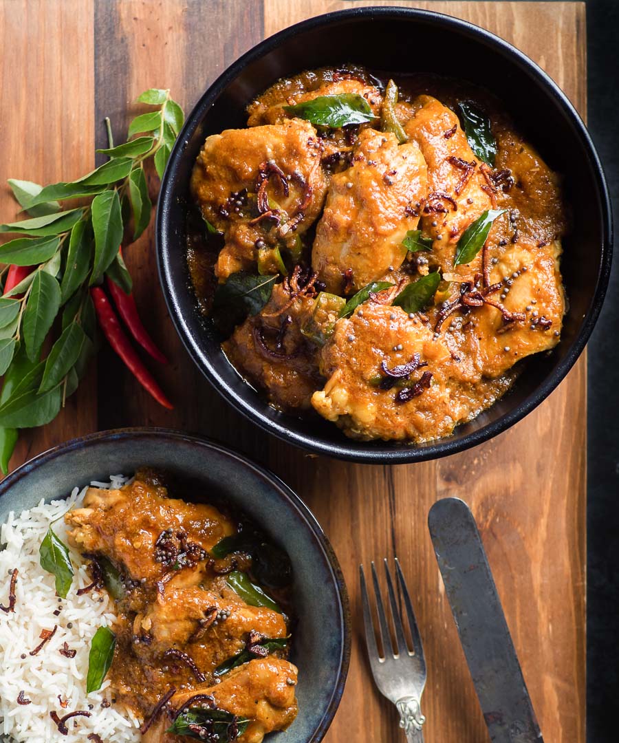 Nadan chicken curry in a black bowl from above.