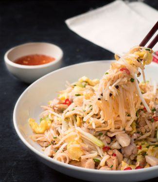 Chicken pad thai mouthful with chopsticks.