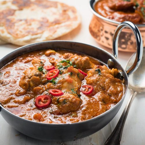 Restaurant karahi chicken in an Indian styles serving dish.