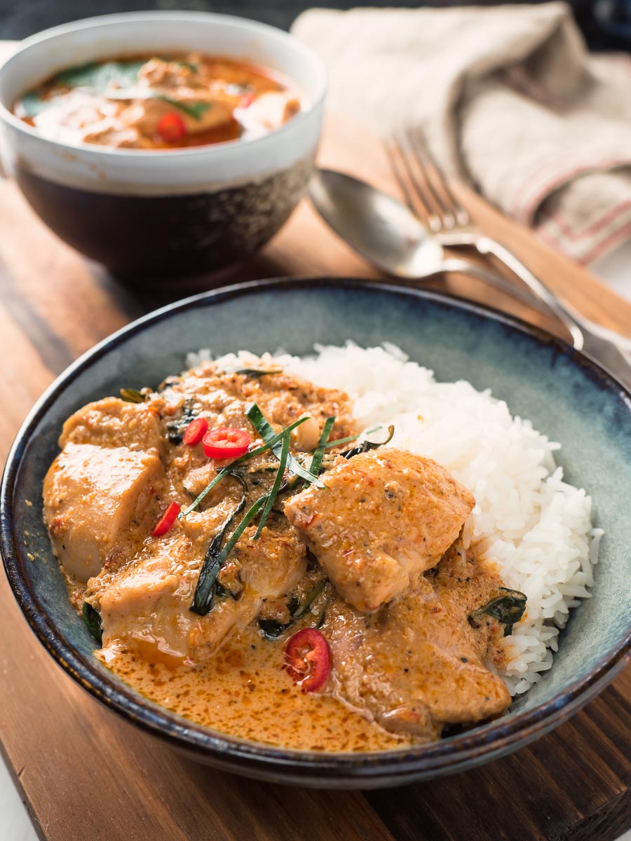 Panang curry and rice in a blue ceramic bowl.