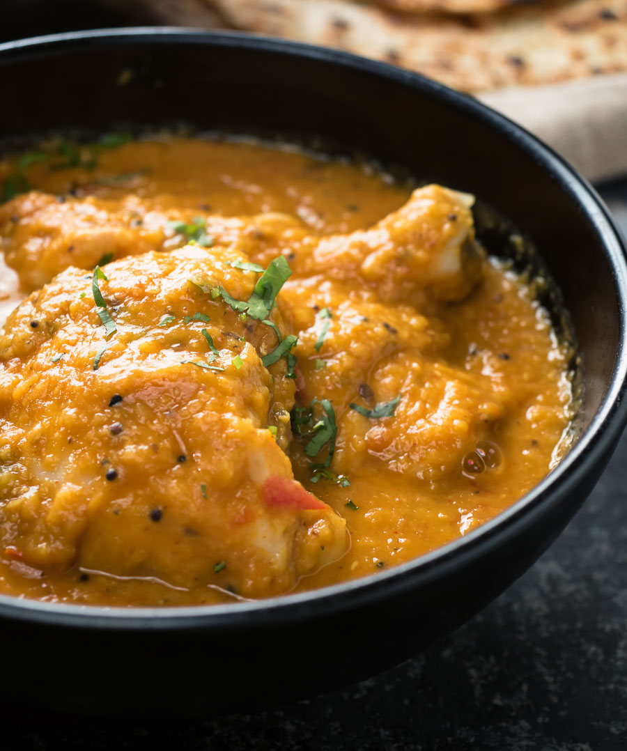 chicken dhansak in a black bowl close up.