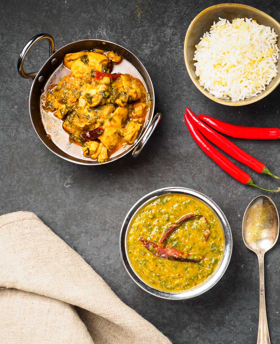 Dal palak, lemon chicken with coriander and rice in bowls from above.