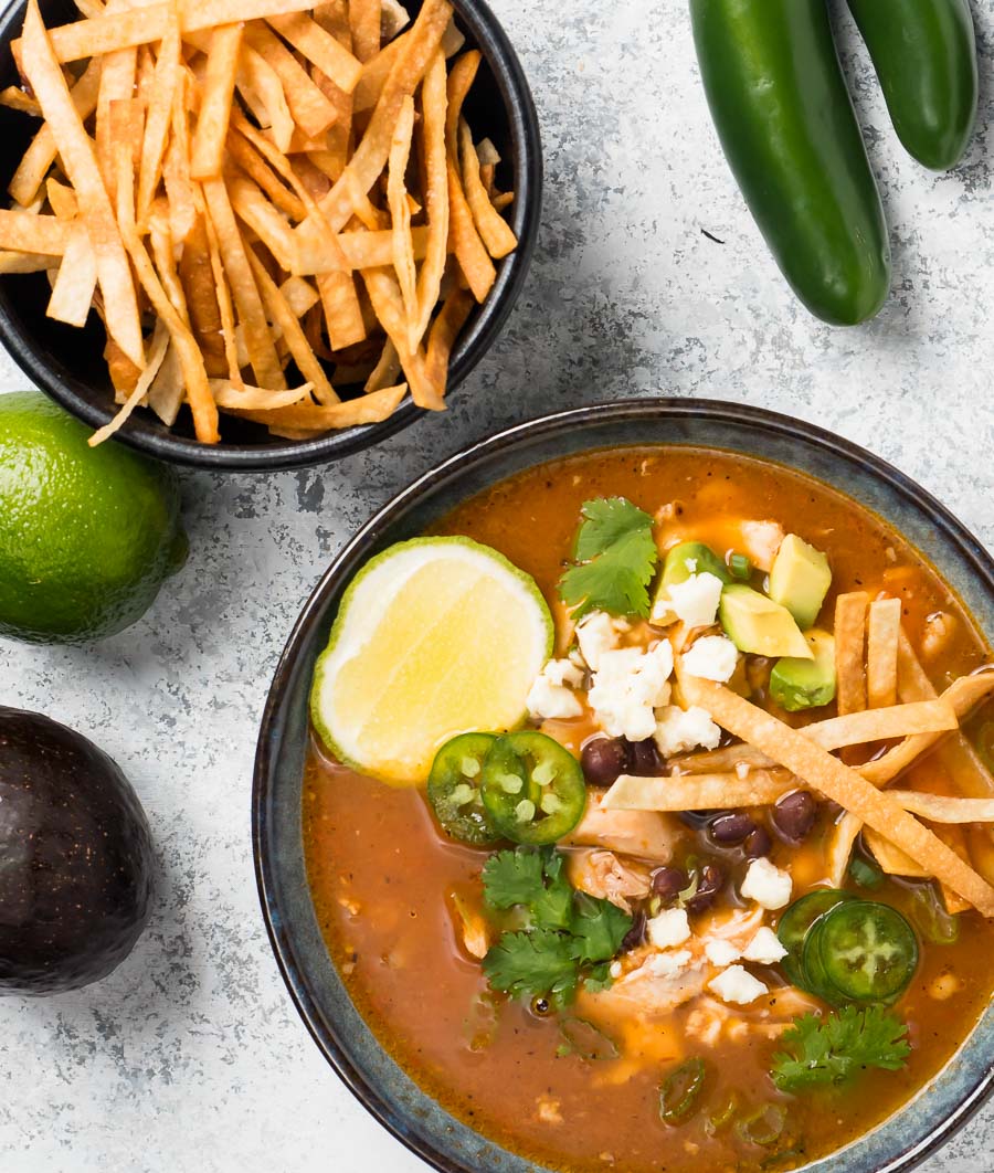 Chicken tortilla soup in a blue bowl from above.