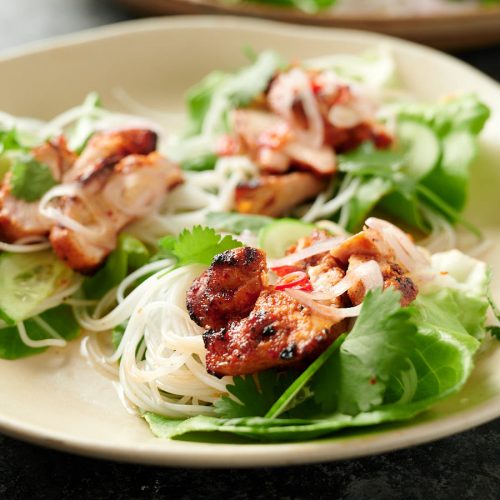 Three spicy Korean chicken lettuce wraps on a plate.