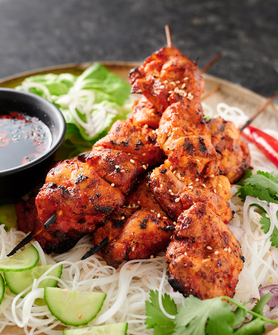 Spicy chicken skewers on a platter.