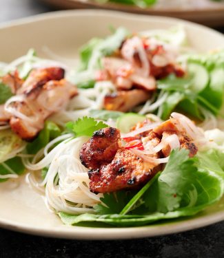 Three spicy Korean chicken lettuce wraps on a plate.