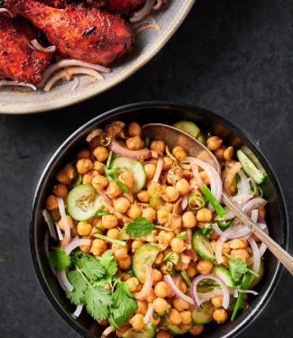 Chana chaat in a serving bowl with spoon from above.