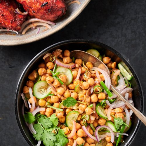 Chana chaat in a serving bowl with spoon from above.