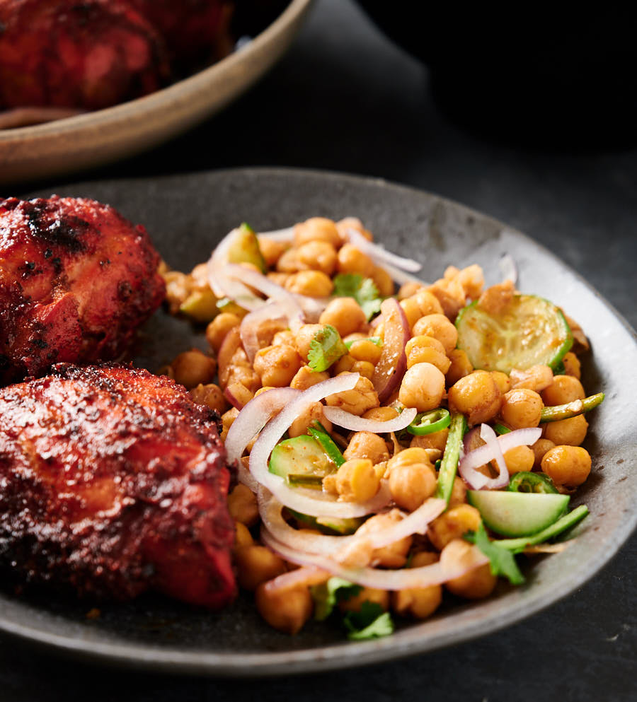 Plate of chana chaat with tandoori chicken from the front (close up).