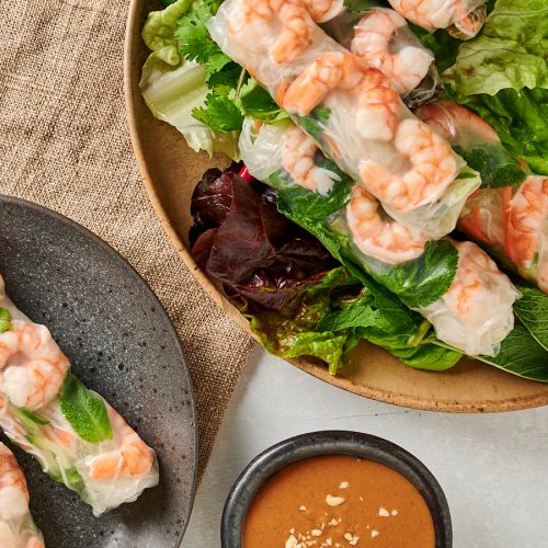 Overhead view of Vietnamese spring rolls on a platter and plate.