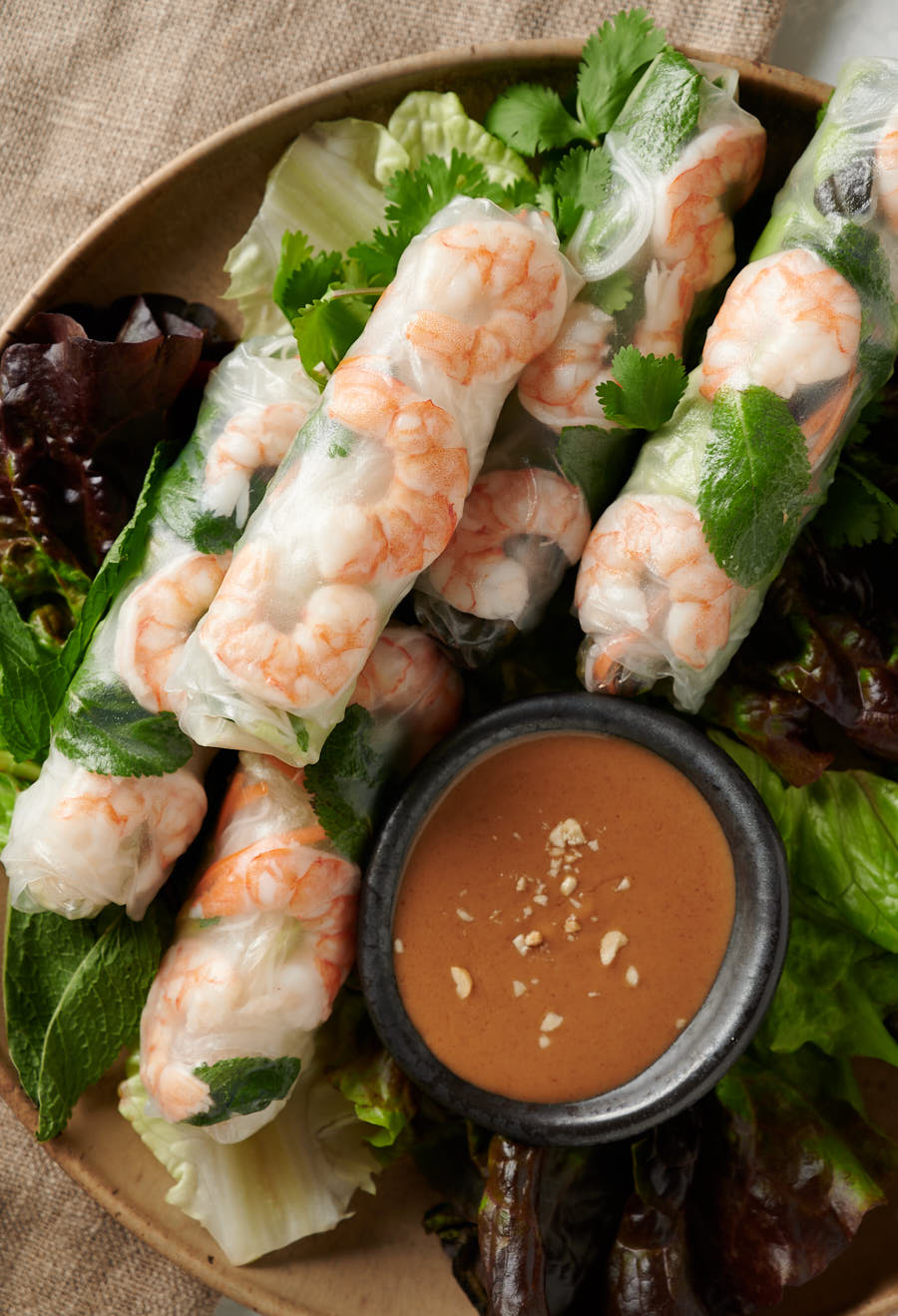 Vietnamese spring rolls with peanut sauce on a platter from above.