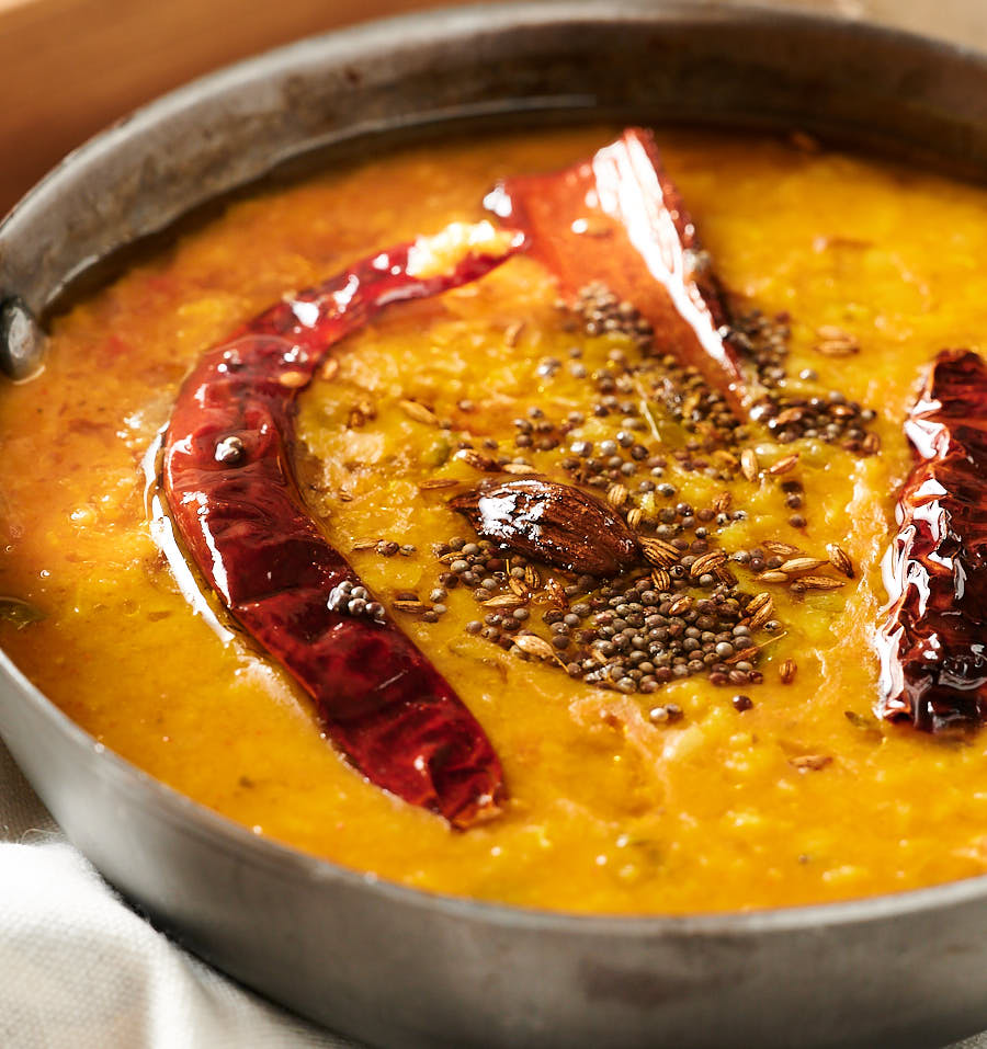 Close up of dal tadka with whole spices tempering.
