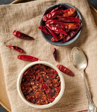 Table scene of chilies and nam prik pao from above.