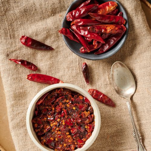 Table scene of chilies and nam prik pao from above.