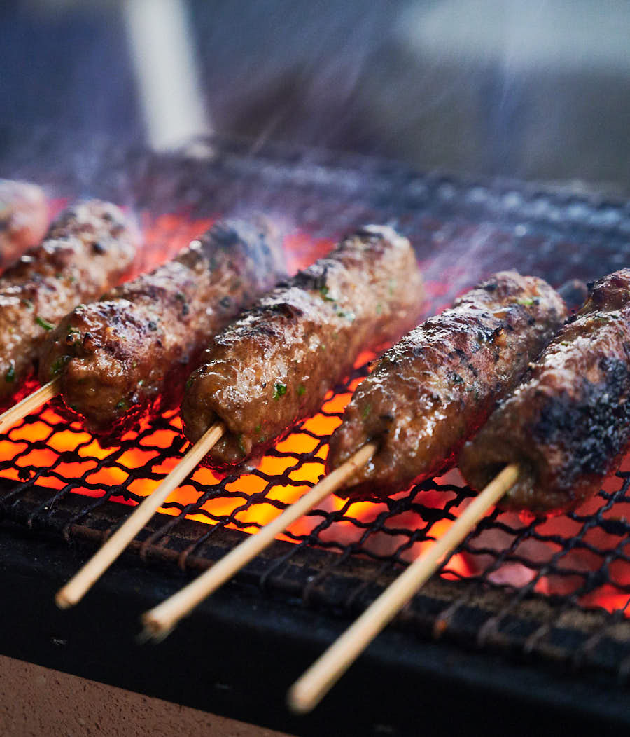 Indian seekh kebab cooking on a grill.