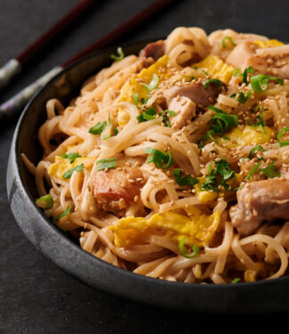 Thai sesame noodles on a black Asian plate.