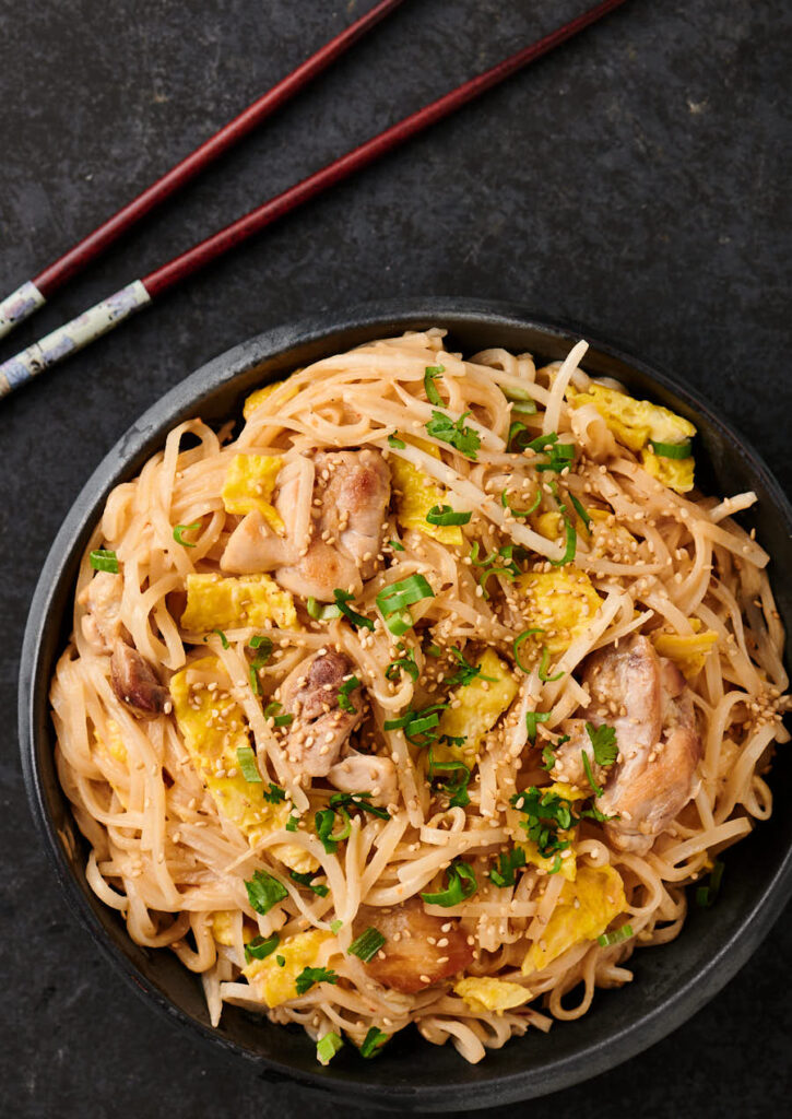 Thai sesame noodles on a black plate from above.