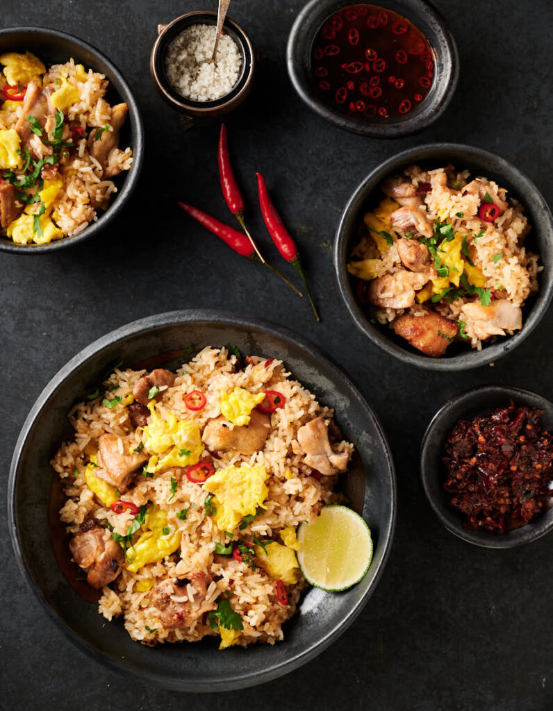 Thai fried rice bowl with garnishes surrounding it - from above.