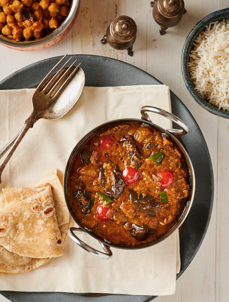 Baingan masala or eggplant curry in an Indian karai from above.