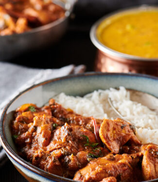 Serving of chicken bhuna and rice from the front.