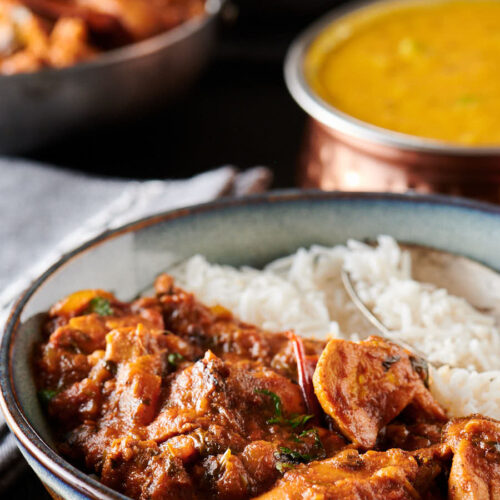 Serving of chicken bhuna and rice from the front.