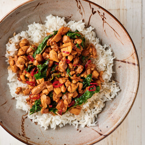 Bowl of Thai basil chicken on a bed of rice.