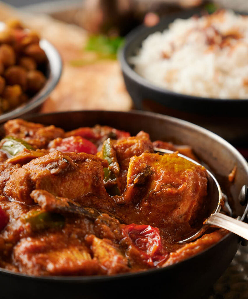 Closeup of a spoonful of garlic chilli chicken curry from the front.