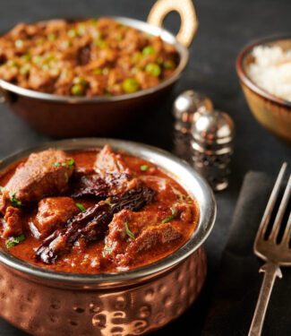 Lamb vindaloo, keema matar and rice table scene from the front.