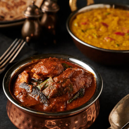 Ceylon chicken curry, dal , chapatis and cutlery table scene from the front.