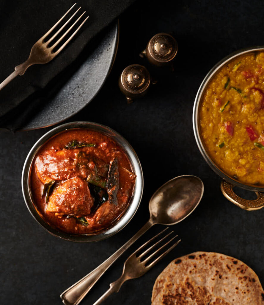 Table scene - Ceylon chicken curry, dal with tomato and green chili and chapatis from above.