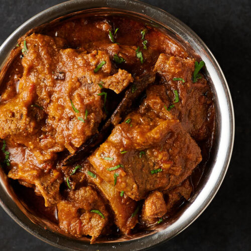 Indian hotel style lamb madras in a copper bowl from above.